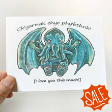 Load image into Gallery viewer, A greeting card with art of a baby Cthulhu with arms out stretched, with the words, "Ck'yarnak ehye phy'bthnk! [I love you this much!]"

