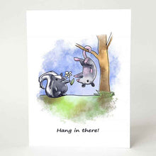 Load image into Gallery viewer, a greeting card printed with an illustration of a skunk holding out a flower towards a possum hanging upside down, with the text, "Hang in there!"

