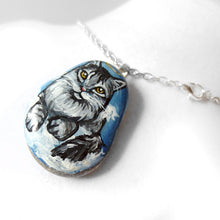 Load image into Gallery viewer, art of a silver gray maine coon cat as an angel, is hand painted on a river rock, and is available as either a keepsake, magnet or a pendant necklace
