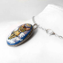 Load image into Gallery viewer, art of an Abyssinian cat, painted as an angel in the clouds. hand painted on a beach stone, available as a keepsake or pendant necklace

