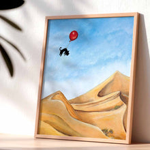 Load image into Gallery viewer, An art print with an illustration of a black cat floating with a red balloon, soaring over the Saraha desert
