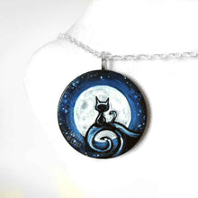 Load image into Gallery viewer, a wood disc, hand painted with a small black cat sitting on a curly hill, against a large full moon and starry night sky. this piece is available as a keepsake o rpendant necklace
