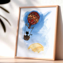 Load image into Gallery viewer, Art print of a black cat sitting in a hot air balloon, floating in a blue sky with the sun
