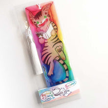 Load image into Gallery viewer, A PET (polyethylene terephthalate) bookmark and white tassel, featuring a character from Rainbow of Crazy Comics reading in a cozy, colourful box: a tabby cat reads a book with a cat on the cover. on the bottom, it says @ Rainbowofcrazy. The bookmark is packaged in a sleeve with a small band with the text "Rainbow of Crazy Comics bookmark"
