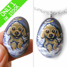 Load image into Gallery viewer, a small beach stone hand painted with the portrait of a brown poodle as an angel, sitting in the clouds against a blue sky. available as a keepsake or pendant necklace
