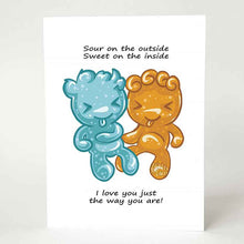 Load image into Gallery viewer, A greeting card with art of two sour candies in the shape of people (one blue, one orange), the card reads, "Sour on the outside / Sweet on the inside / I love you just the way you are!"

