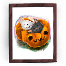 Load image into Gallery viewer, an art print featuring an illustration of a black cat and white cat napping together in a blanket shaped like a jack o'lantern
