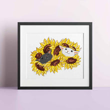 Load image into Gallery viewer, an art print featuring an illustration of a black cat and white cat peeking out from a bunch of sunflowers
