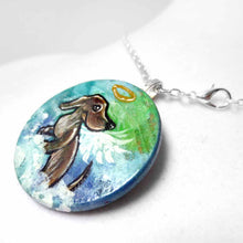Load image into Gallery viewer, a lightweight wood disc, hand painted with the portrait of a dachshund, as an angel, sitting on fluffy clouds against a green and blue sky. available as a keepsake or pendant necklace 
