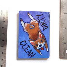 Load image into Gallery viewer, blue and purple wood magnet, hand painted with a corgi with a tail in a heart shape, tongue out, doing a sploot. near the top of the dog's head is the word CLEAN. written upside down next to the dog's butt is the word DIRTY
