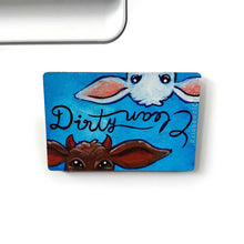 Load image into Gallery viewer, blue wood magnet, hand painted, bottom features a brown goat with little red horns with the word "Dirty" above them. at the top, upside down is a white goat, with the word "clean" above them
