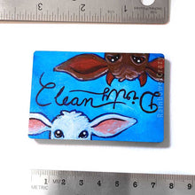 Load image into Gallery viewer, blue wood magnet, hand painted, bottom features a brown goat with little red horns with the word "Dirty" above them. at the top, upside down is a white goat, with the word "clean" above them
