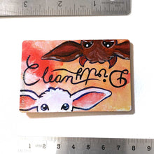 Load image into Gallery viewer, yellow/red wood magnet, hand painted, bottom features a white goat, with the word "clean" above them, at the top, upside down is a brown goat with little red horns with the word "Dirty" above them
