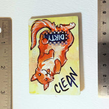 Load image into Gallery viewer, yellow wood magnet, hand painted with an orange cat with its tongue out. near the top of the cat's head is the word CLEAN. a black bar covers the cat's crotch and says the word DIRTY. around the bar, the cat's body is pixelated
