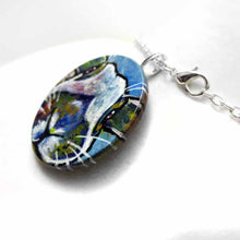 Load image into Gallery viewer, a small round wood disc, hand painted with a portrait of an English Spot rabbit, face up close, painted in rainbow colours. it's available as a keepsake or pendant necklace
