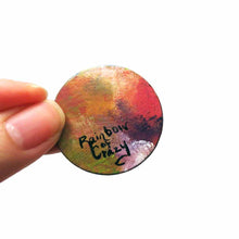 Load image into Gallery viewer, a small round wood disc, hand painted with a portrait of an English Spot rabbit, face up close, painted in rainbow colours. it's available as a keepsake or pendant necklace, back signed with Rainbow of Crazy
