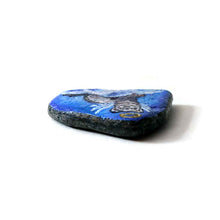 Load image into Gallery viewer, a small beach stone, painted with a portrait of a ferret as an angel in the clouds
