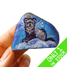 Load image into Gallery viewer, a small beach stone, painted with a portrait of a ferret as an angel in the clouds
