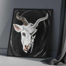 Load image into Gallery viewer, an illustration features a split image: a white horned goat's head on the left side, and a darker, stylized goat skull on the right
