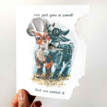 Load image into Gallery viewer, a funny greeting card with two goats: a brown goat and a black goat, on the front, with the piece from the top right, and piece from the bottom right corner of the card ripped and hanging from their mouths. the card reads, "We got you a card! But we eated it"
