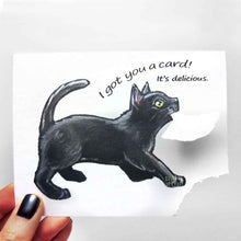 Load image into Gallery viewer, a greeting card, illustrated with a black cat. the bottom right corner of the card has been ripped and hangs from the cat's mouth. card reads, "i got you a card! it's delicious."
