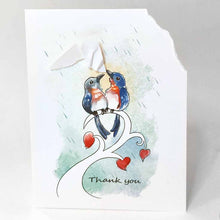 Load image into Gallery viewer, a handmade greeting card wtih an illustration of two bluebirds on a tree branch. the top right corner of the card is ripped off and hangs from one bluebird's mouth, as it holds it up above the other bird, protecting it from the rain. the card says, "thank you"
