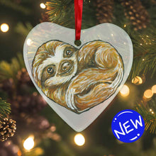 Load image into Gallery viewer, a heart shaped glass ornament, featuring an illustration of a sloth, curled up in the shape of a heart 
