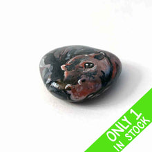 Load image into Gallery viewer, a smooth, flat, beach stone hand painted with a smiling hippo
