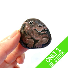Load image into Gallery viewer, a hand holding a smooth, flat, beach stone hand painted with a smiling hippo
