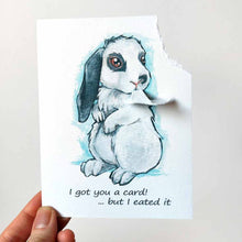 Load image into Gallery viewer, a greeting card with art of a white and gray mini lop rabbit. The card reads, "I got you a card! ... but I eated it". be the top right corner of the card is ripped and hangs from the rabbit's mouth
