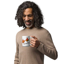 Load image into Gallery viewer, person holding a 11 oz white ceramic mug, printed with art of two maple leaves with happy faces, and the words. "I be-leaf in you"
