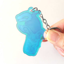 Load image into Gallery viewer, The back of the rabbit acrylic keychain, showing the clear, blue tinted acrylic.
