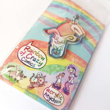 Load image into Gallery viewer, A clear, blue-tinted holographic acrylic keychain featuring a character from Rainbow of Crazy Comics: an English spot rabbit, lying down, admires a potted plant. The keychain is packaged with a backing card, decorated with a rainbow, and the text "Rainbow of Crazy Comics", along with the character cast.
