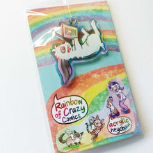 Load image into Gallery viewer, A clear, rainbow holographic acrylic keychain featuring a character from Rainbow of Crazy Comics: a smiling mini lop rabbit lounges on his back as he reads a book with a picture of a rabbit on the back. The keychain is packaged with a backing card, decorated with a rainbow, and the text "Rainbow of Crazy Comics", along with the character cast.
