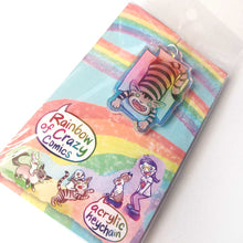Load image into Gallery viewer, A clear, blue tinted holographic acrylic keychain featuring a character from Rainbow of Crazy Comics: a smiling tabby cat lounges in a cardboard box. The keychain is packaged with a backing card, decorated with a rainbow, and the text "Rainbow of Crazy Comics", along with the character cast.
