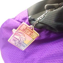 Load image into Gallery viewer, A clear, rainbow holographic acrylic keychain featuring a character from Rainbow of a Crazy Comics: a smiling white rabbit at a homemade booth that says "bunny help $20" at the top, and "the doctor is in" at the bottom. 
