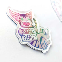 Load image into Gallery viewer, An acrylic magnet featuring a character from Rainbow of Crazy Comics: a tabby cat smiles and holds up a sign that says "HYDRATE PLEASE?!". 
