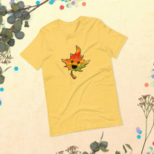 Load image into Gallery viewer, a t-shirt in the colour yellow, featuring a smiling maple leaf
