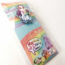 Load image into Gallery viewer, A glittery acrylic pin featuring a character from Rainbow of Crazy Comics: a mini lop rabbit hugging a book, with a tiny heart next to him. packaging includes other characters from Rainbow of Crazy Comics
