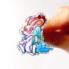Load image into Gallery viewer, A glittery acrylic pin featuring a character from Rainbow of Crazy Comics: Linus an English spot rabbit, smiles as he cuddles a light blue blanket.
