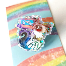 Load image into Gallery viewer, An acrylic pin featuring a character from Rainbow of Crazy Comics: a smiling birman cat watching a bird video on a tablet.
