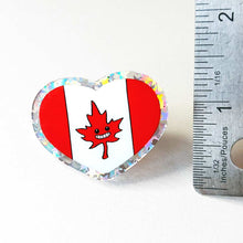 Load image into Gallery viewer, A glittery acrylic pin featuring a character from Rainbow of Crazy Comics: the Canada flag with a stylized maple leaf with happy face. 1.5 inches.
