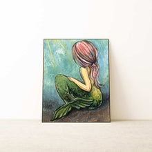 Load image into Gallery viewer, An art print of a mermaid sitting on the ocean floor, looking away from the viewere, as long pink hair flows down her back
