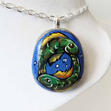 Load image into Gallery viewer, small rock art featuring a painting of two green fish, swimming in the shape of a circle, representing the sign of pisces, available as a keepsake, magnet or necklace
