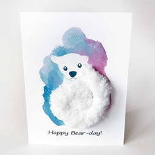 Load image into Gallery viewer, a greeting card with an illustration of a polar bear. thick, fluffy white yarn makes up the bear's body. the background has a splash of blue and purple. the front says, "Happy Bear-day!"
