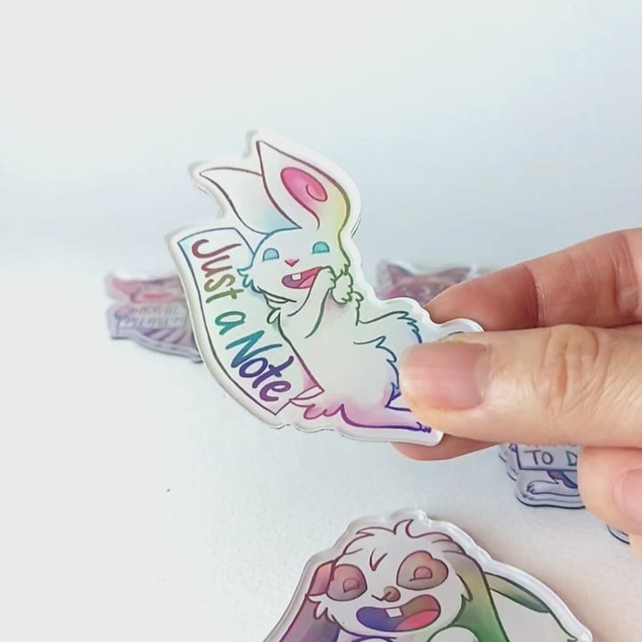 Video of a hand tilting the white rabbit magnet back and forth to showcase the holographic finish.
