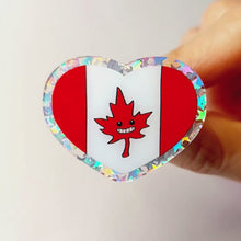 Load and play video in Gallery viewer, A glittery acrylic pin featuring a character from Rainbow of Crazy Comics: the Canada flag with a stylized maple leaf with happy face.
