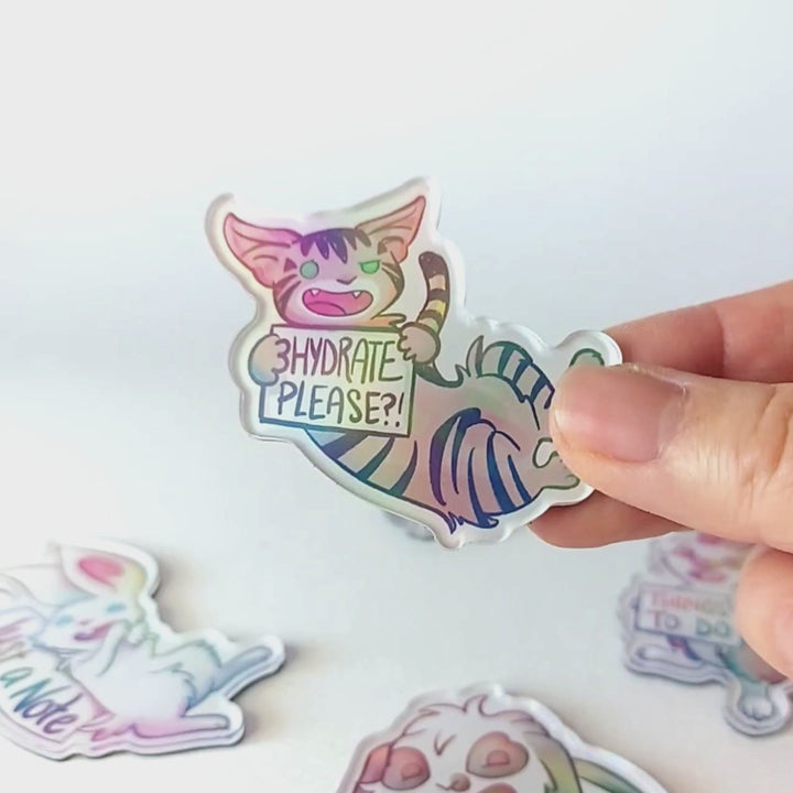 Video of a hand tilting the cat magnet back and forth to showcase the holographic finish.