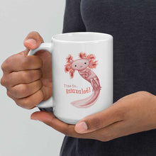 Load image into Gallery viewer, hands holding a white ceramic mug, 15 oz size, with an illustration of a smiling axolotl next to the text "Time to.. Relaxalotl"
