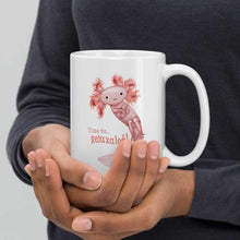 Load image into Gallery viewer, hands holding a white ceramic mug, 15 oz size, with an illustration of a smiling axolotl next to the text "Time to.. Relaxalotl"
